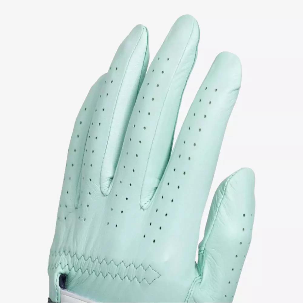 A close-up of a light turquoise leather glove, showing perforations on the fingers for ventilation and detailed stitching near the wrist&mdash;an essential accessory for those seeking the best golf bags 2026. The glove is worn on a left hand against a plain white background.