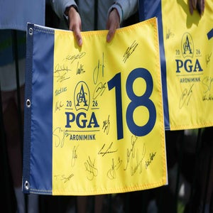 2026 PGA Championship Sunday TV coverage: Fan watches PGA and holds yellow flag at Aronimink.