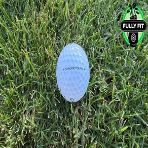 A Callaway Chrome Tour X golf ball sits on green grass.
