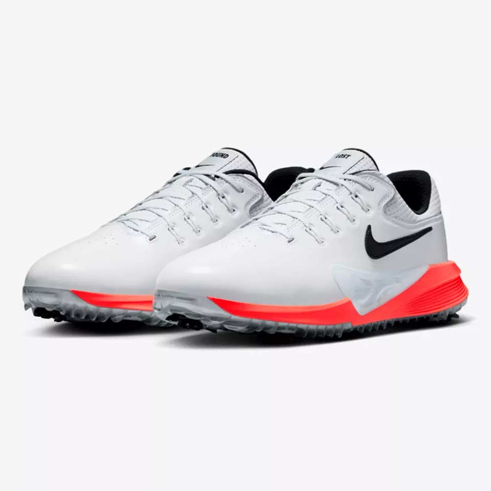 A white Scottie Scheffler-inspired pair of Nike golf shoes with black swooshes, black inner lining and bright red accents on the midsole and outsole, displayed on a light background.