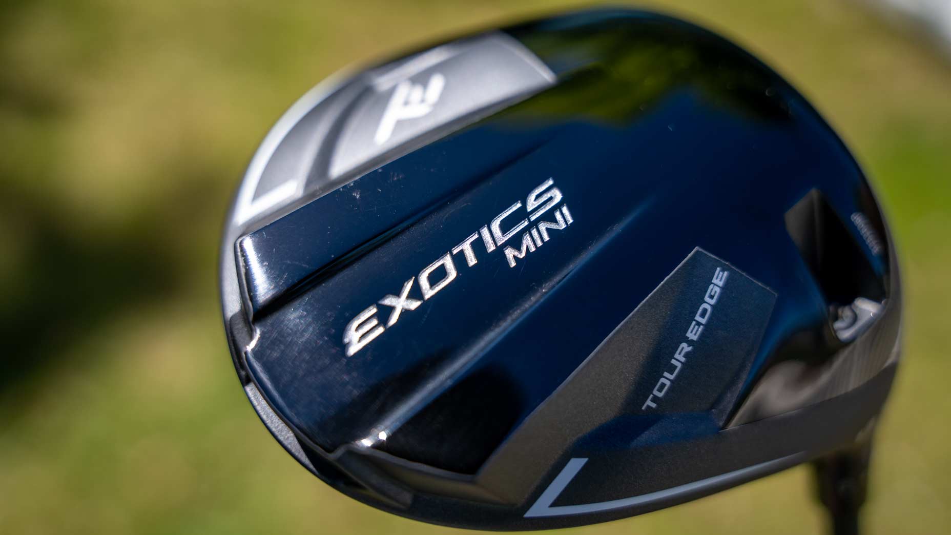 Tour Edge Exotics Mini Driver in-hand photo on golf course.