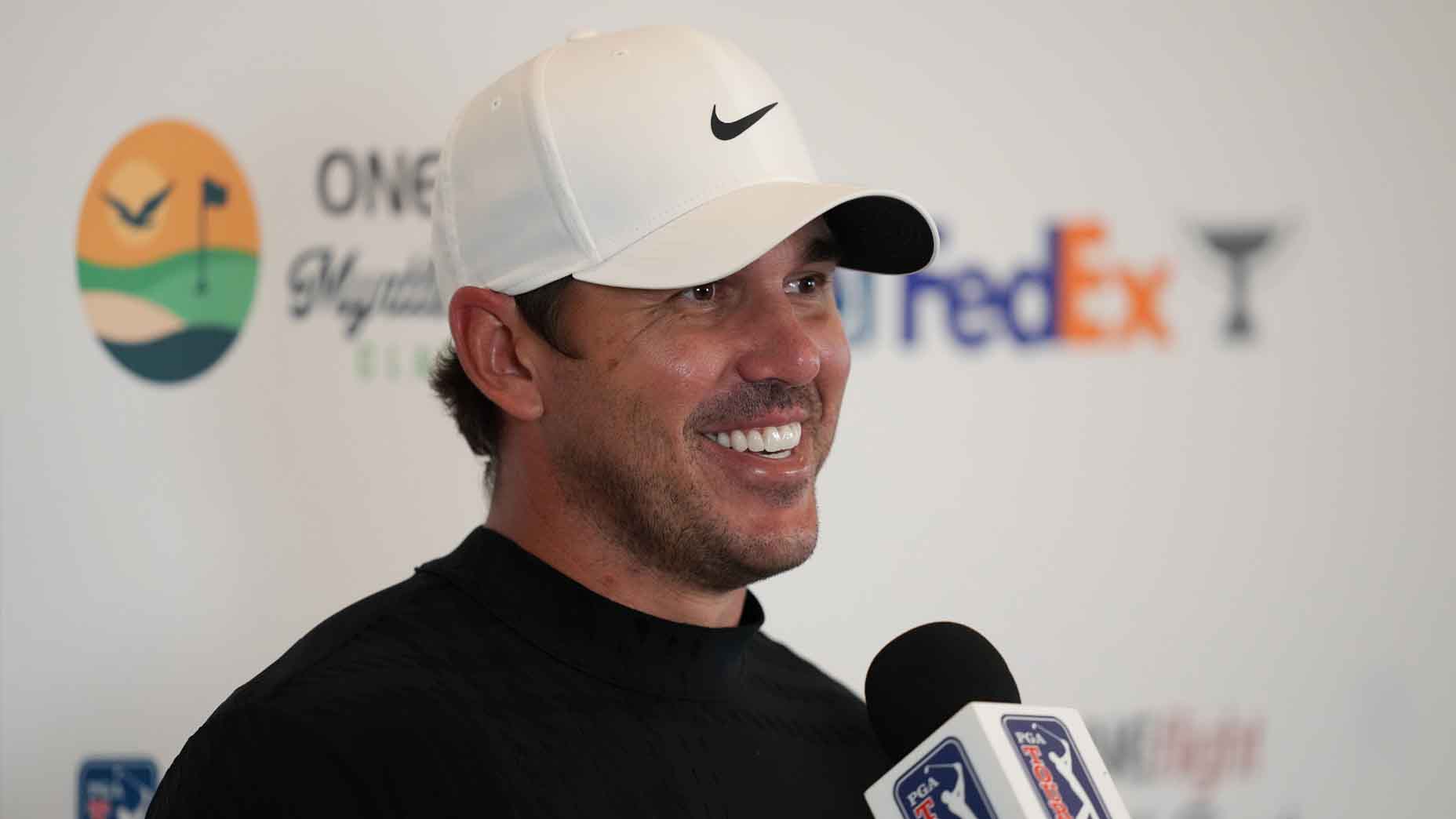 Brooks Koepka smiles while addressing the media