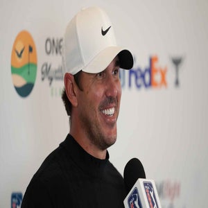 Brooks Koepka smiles while addressing the media