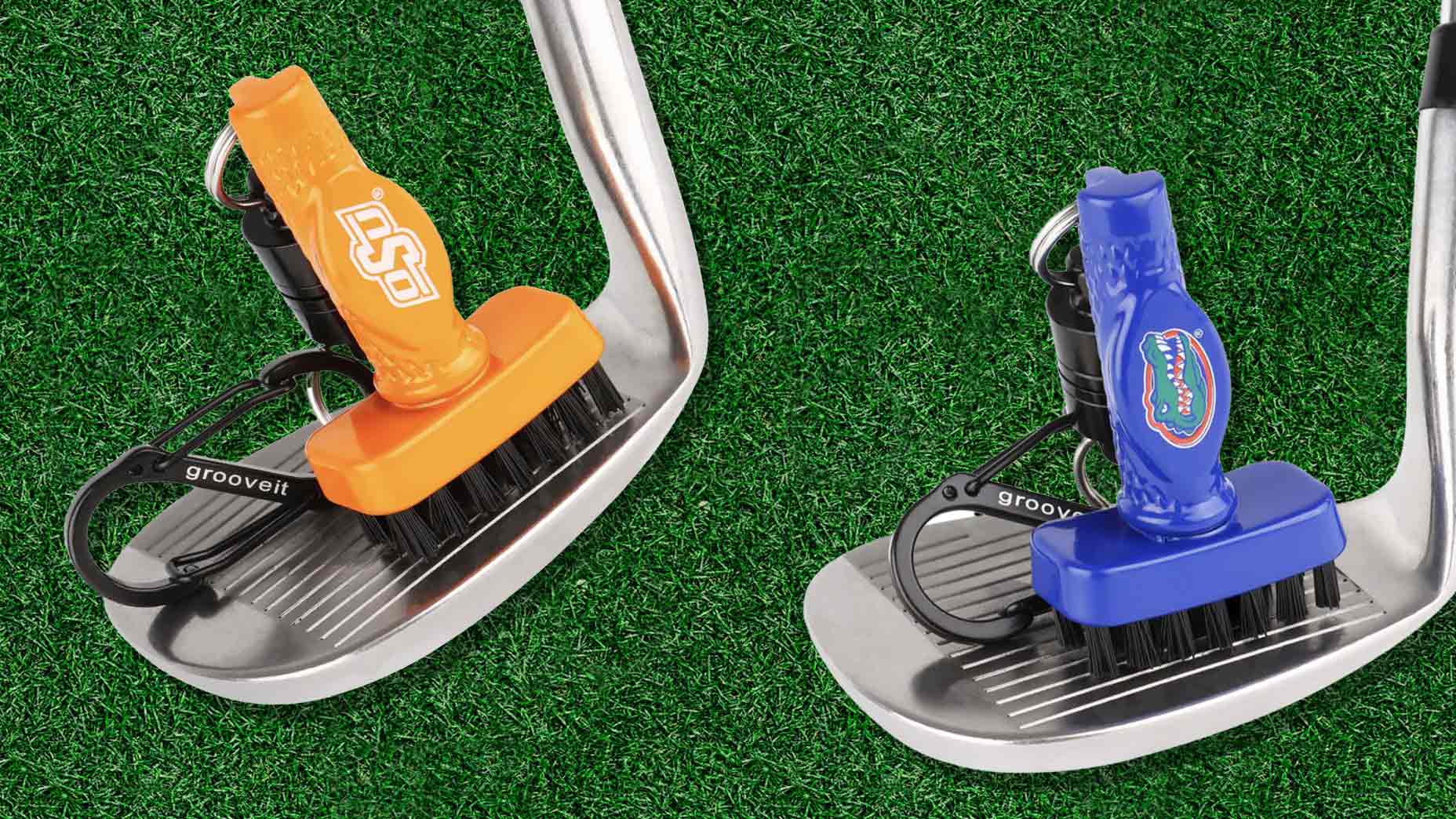 Two club brushes, one orange and one blue, are attached to golf irons on green grass. Each brush showcases your alma mater’s logo and features sturdy black bristles with retractable clips for easy cleaning.