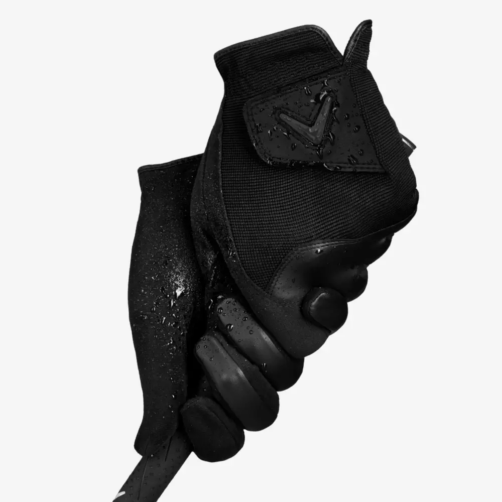 A black grip with water drops grips a golf club grip, shot against a plain white background—perfect for highlighting 6 golf deals worth buying now.
