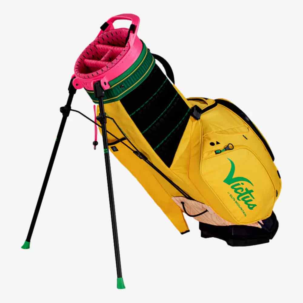 A yellow pencil golf bag with a green and pink top, green accents and the word Virtue printed on the side. This Sun Mountain golf bag features a black two-legged stand and multiple storage pockets.